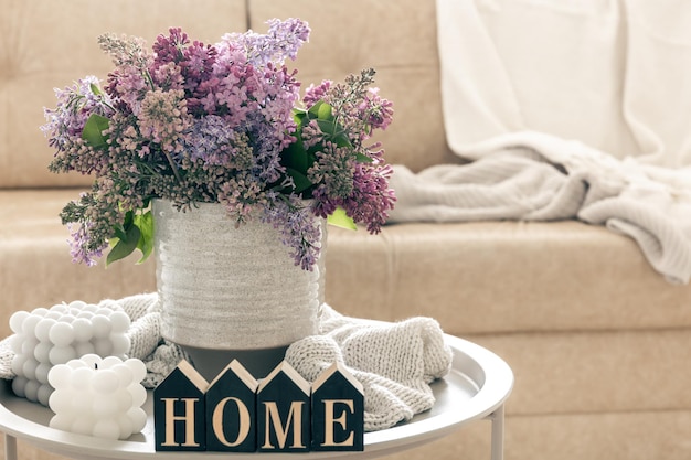 Gratis foto samenstelling met lila bloemenkaarsen en decoratief woordhuis