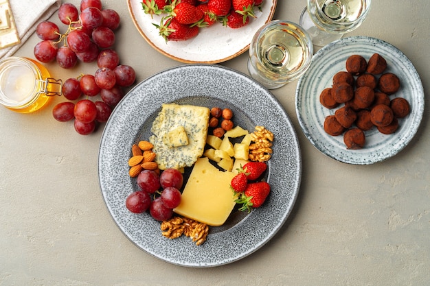 Samenstelling van kaas en fruit op grijze tafel