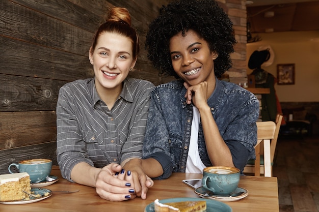 Samesex homoseksuele vrouwelijke partners koffie drinken en gebak eten in restaurant