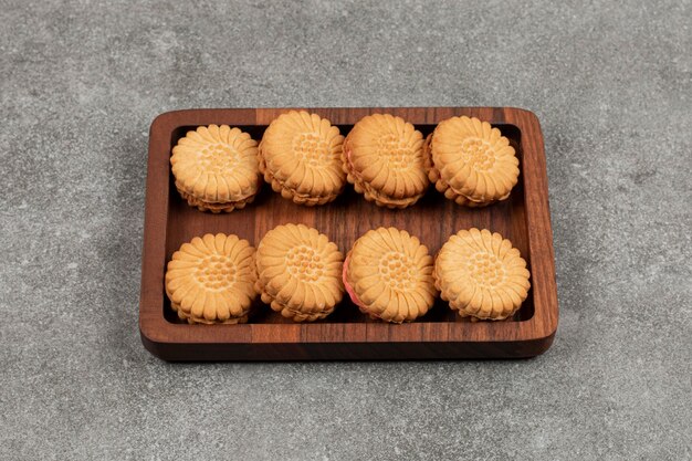 Sandwichkoekjes gevuld met room op houten plaat