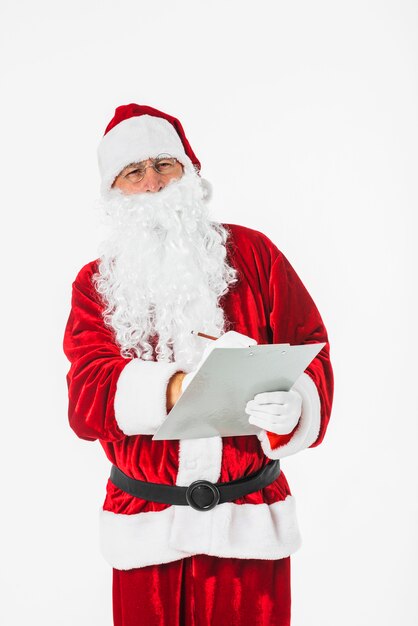 Santa Claus die op papier met potlood schrijft