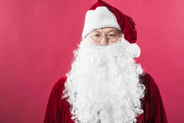 Santa Claus in glazen die zich op rode achtergrond bevinden