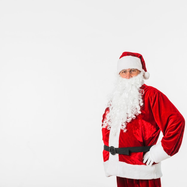 Santa Claus in rode hoed die zich met handen op heupen bevindt
