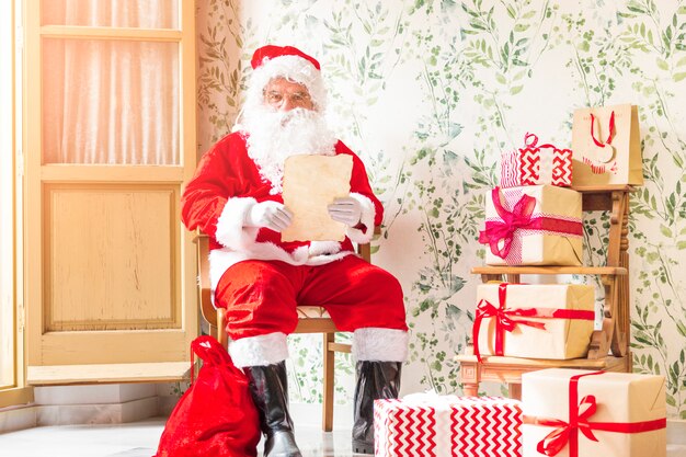 Santa Claus-zitting op stoel met brief