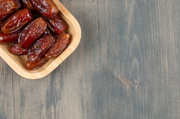 Sappige datums in een houten plaat op een houten tafel. Hoge kwaliteit foto