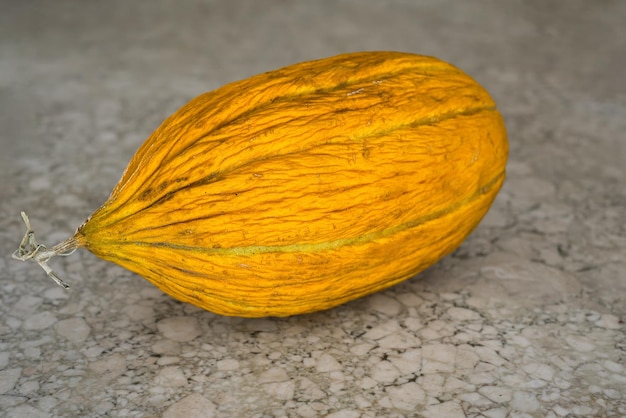 Gratis foto sappige gele meloen op een stenen tafel close-up selectieve focus op de bes het idee om reclame te maken voor biologisch fruit van de boerenmarkt achtergrond of artikelconcept