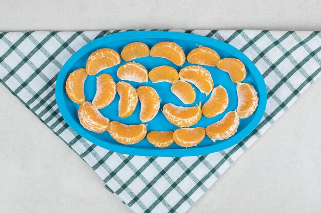 Sappige mandarijnsegmenten op blauw bord