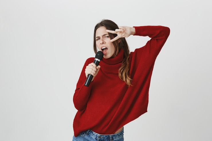 Gratis Foto sassy leuke vrouw die in karaoke zingt, toont vredesteken