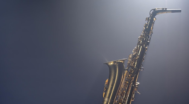 Gratis foto saxofoon op een donkere achtergrond met rook kopie ruimte