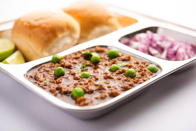 Schapenvlees kheema pav of indiaas pittig gehakt geserveerd met brood of kulcha, gegarneerd met doperwtjes. humeurige achtergrond. selectieve focus