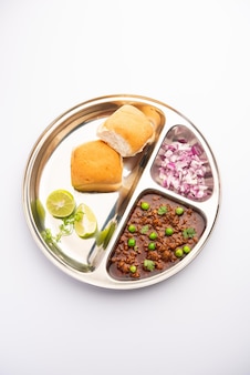 Schapenvlees kheema pav of indiaas pittig gehakt geserveerd met brood of kulcha, gegarneerd met doperwtjes. humeurige achtergrond. selectieve focus