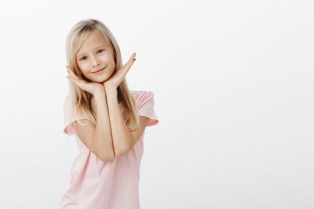 Schattig klein meisje hand in hand over het gezicht, op zoek gelukkig