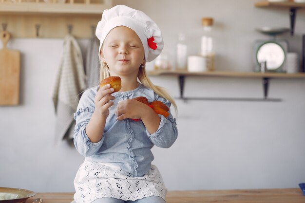 Schattig klein meisje in een keuken met cupcake