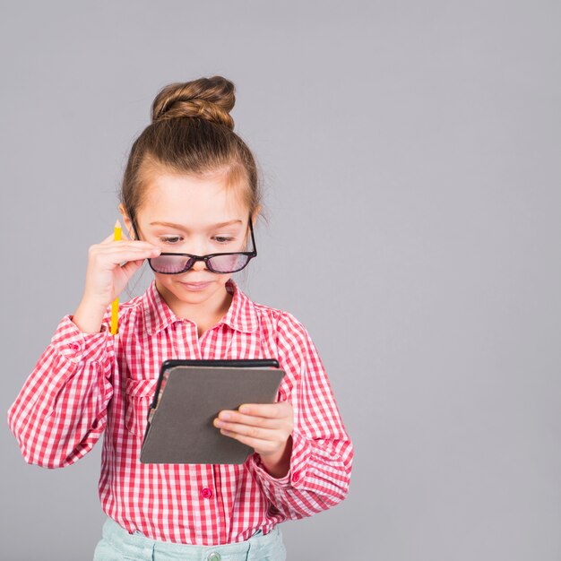 Schattig klein meisje in glazen met behulp van Tablet PC