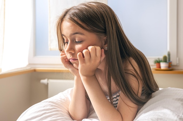 Schattig klein meisje in haar bed vroeg in de ochtend