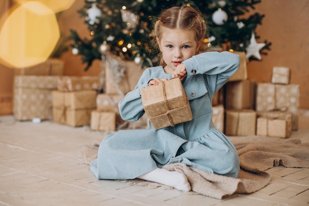 Schattig klein meisje met kerstcadeautjes bij de kerstboom