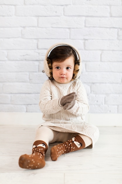 Schattig klein meisje, zittend op de vloer