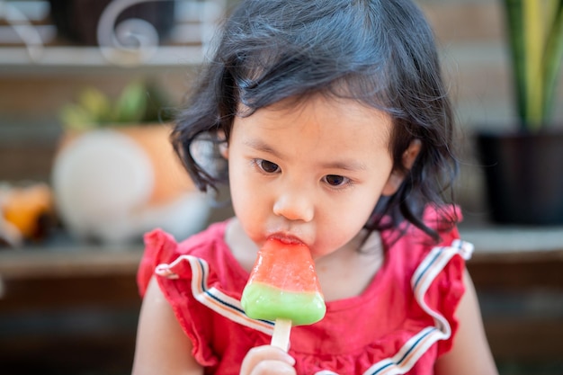 Schattig klein Thais meisje dat een ijsje met watermeloensmaak eet