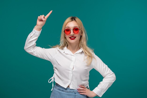 Schattig meisje blond mooi jong meisje in een wit netjes shirt opgewonden met een idee in zonnebril