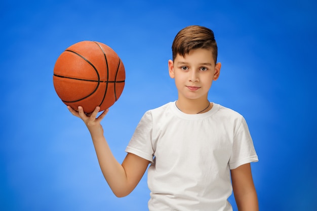 Schattige 11-jarige jongenskind met basketbal bal