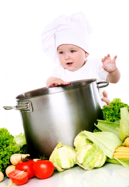 Schattige baby chef-kok met groenten