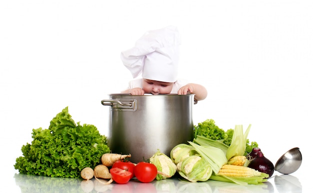 Schattige baby chef-kok met grote pot en groenten