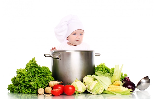 Schattige baby chef-kok met grote pot en groenten