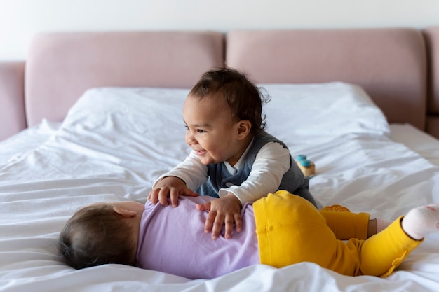 Gratis foto schattige baby's die met elkaar spelen op het bed