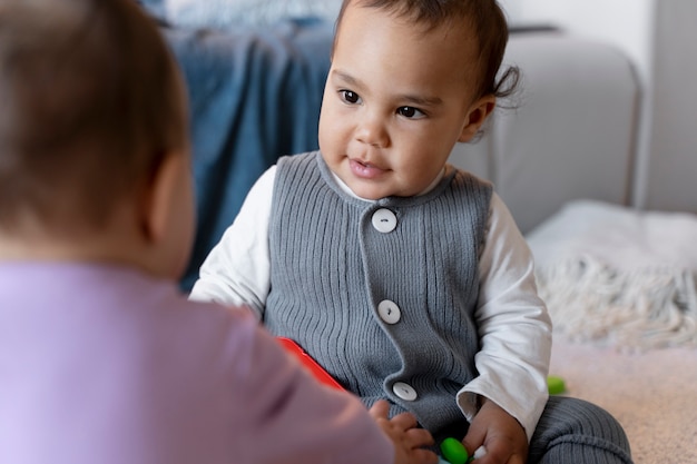 Schattige baby's spelen op de grond met speelgoed