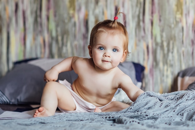 Schattige babymaanden met blauwe ogen lachend thuis bed