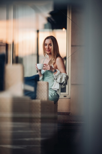 Schattige blanke vrouw zitten en ontbijten met een kopje koffie