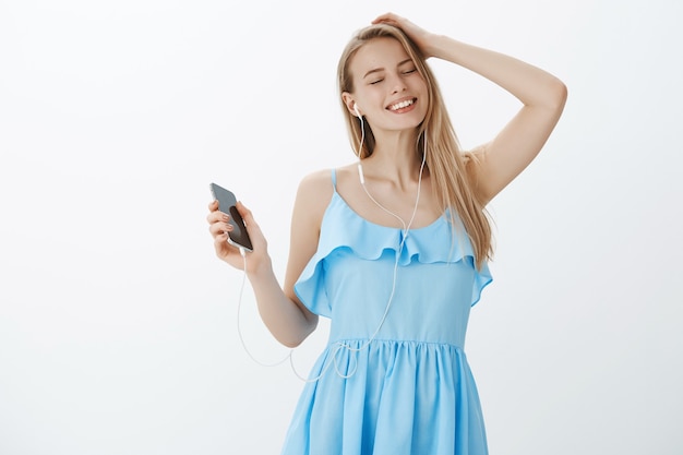 Schattige blonde meisje in een stijlvolle blauwe jurk