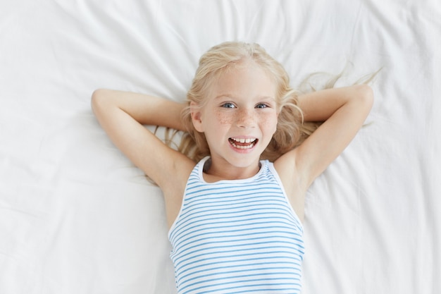 Schattige blonde meisje in witte bed