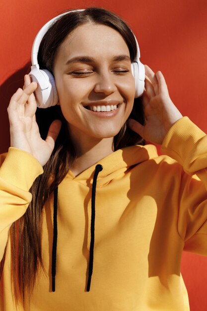 schattige jonge vrouw luister naar de muziek in een koptelefoon buiten