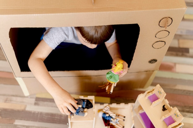 Schattige jongen met kartonnen tv close-up