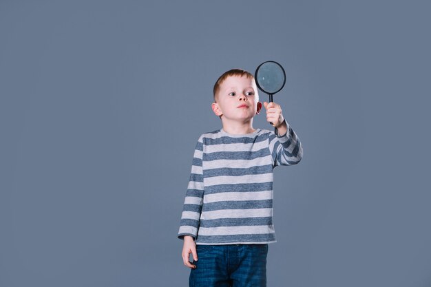 Schattige jongen met vergrootglas