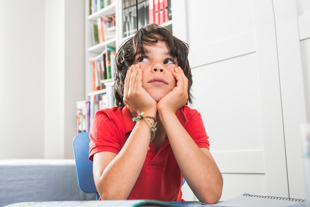 Schattige jongen zitten en denken