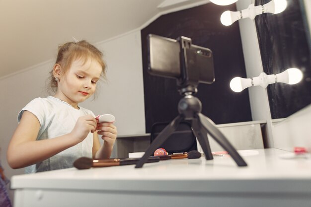 Schattige kleine blogger met cosmetica video opnemen thuis