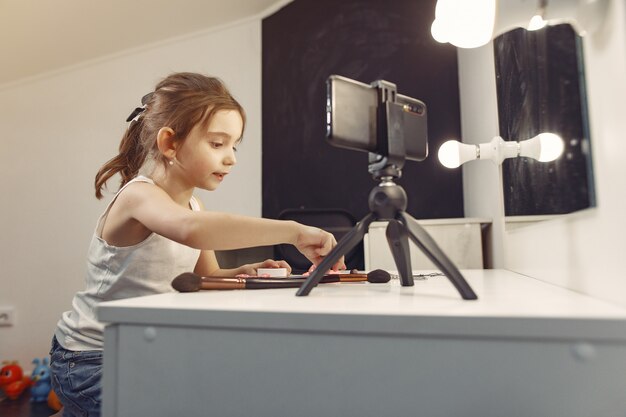 Schattige kleine blogger met cosmetica video opnemen thuis