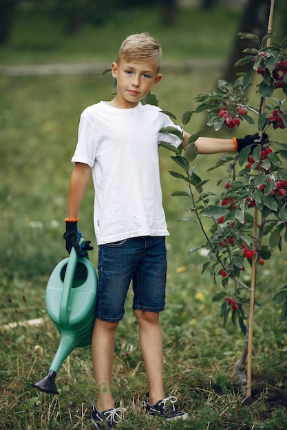 Schattige kleine jongen die een boom plant op een park