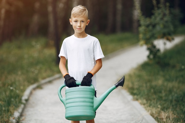 Schattige kleine jongen die een boom plant op een park