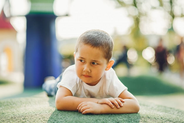 Schattige kleine jongen heeft plezier op een speelplaats