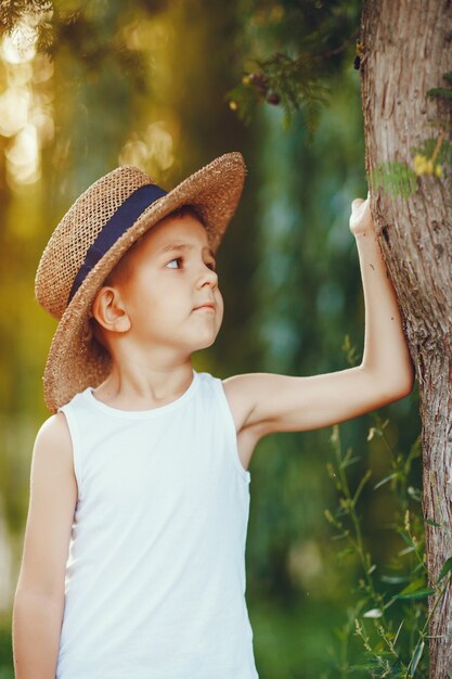Schattige kleine jongen in een hoed tijd doorbrengen in een zomerpark