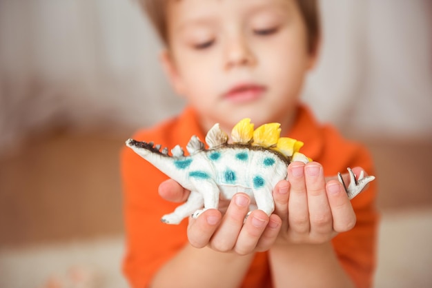 Schattige kleine jongen met een dinosaurus speelgoed. selectieve focus