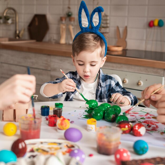 Schattige kleine jongen schilderij traditionele eieren voor Pasen