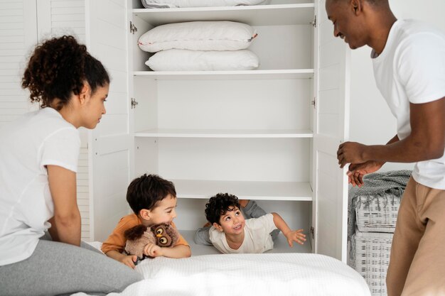 Schattige kleine jongens die zich verstoppen in de kledingkast terwijl ze verstoppertje betaalden