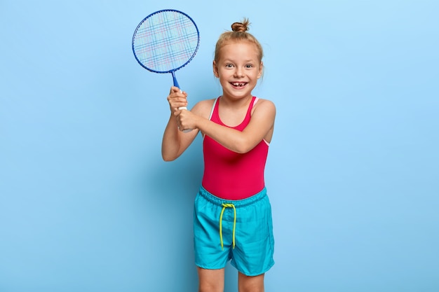Schattige kleine vrouwelijke kind speelt badminton met vrienden
