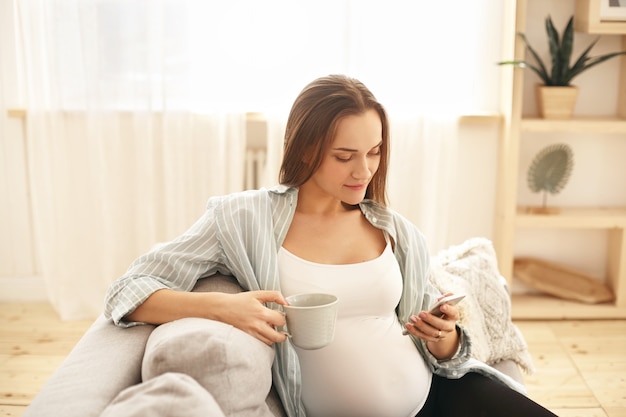 Schattige schattige jonge zwangere vrouw poseren