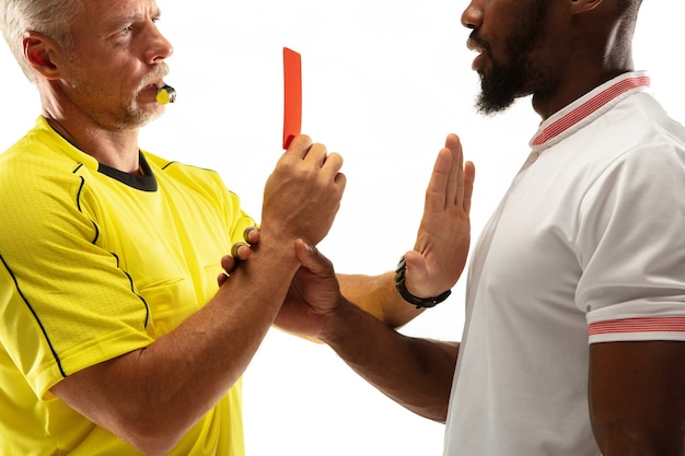 Scheidsrechter die een rode kaart toont aan een ontevreden Afrikaans-Amerikaans voetbal