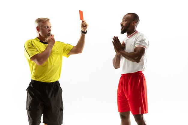 Scheidsrechter die een rode kaart toont aan een ontevreden Afro-Amerikaanse voetbal of voetballer